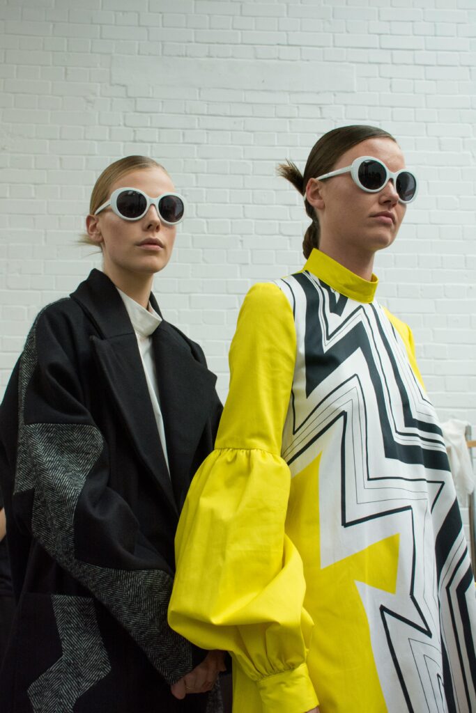 Mannequins qui prennent la pose, dans des tenues noire et jaune.